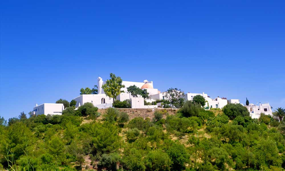 Een heuvel met idyllische witte huisjes in Santa Eulalia op Ibiza